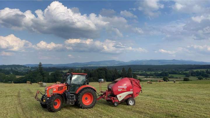 Tracteur agricole Kubota attelé à une presse à balles rondes Puy-de-Dôme
